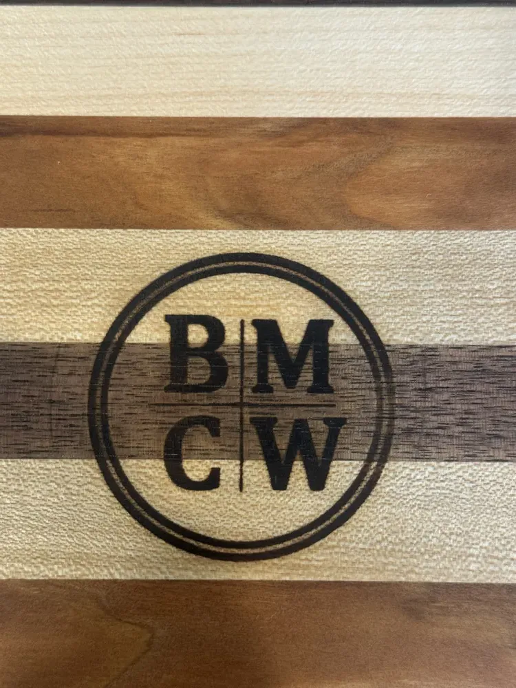 The BMCW monogram branded into a maple and walnut board