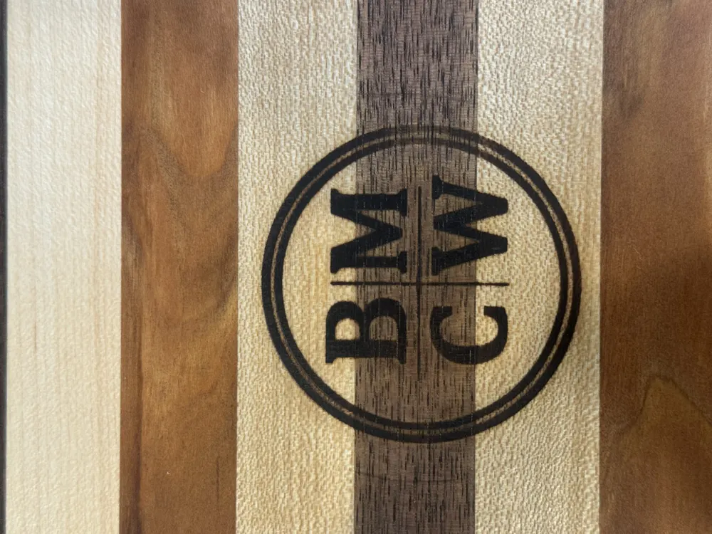 The BMCW monogram branded into a maple and walnut board