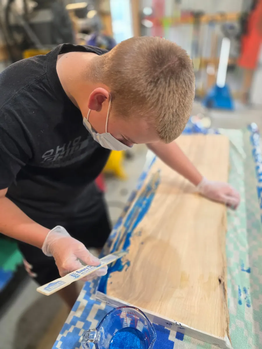 Brody spreading pigmented epoxy across a slab with a stir stick